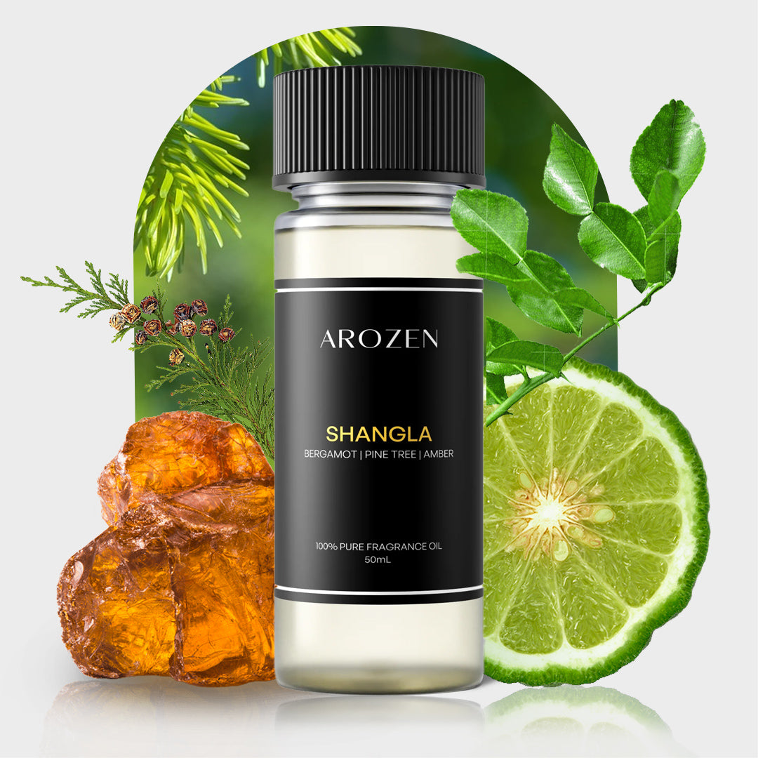 
                  
                    A bottle of SHANGLA fragrance oil sits beside pine needles, amber resin, green leaves, and bergamot—ideal for bringing nature-inspired notes into your space when used in an electric diffuser for a touch of luxury.
                  
                