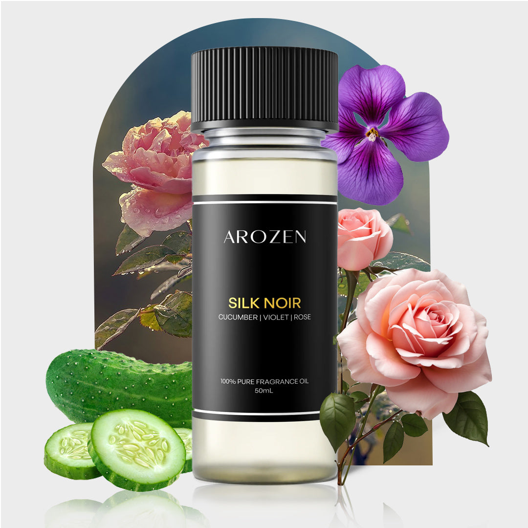 
                  
                    A bottle of SILK NOIR Electric Scent Diffuser Oil is shown, its label featuring cucumber, violet, and rose scents. Fresh cucumbers, pink roses, and purple flowers hint at the luxurious vibe inspired by Hilton Hotels.
                  
                